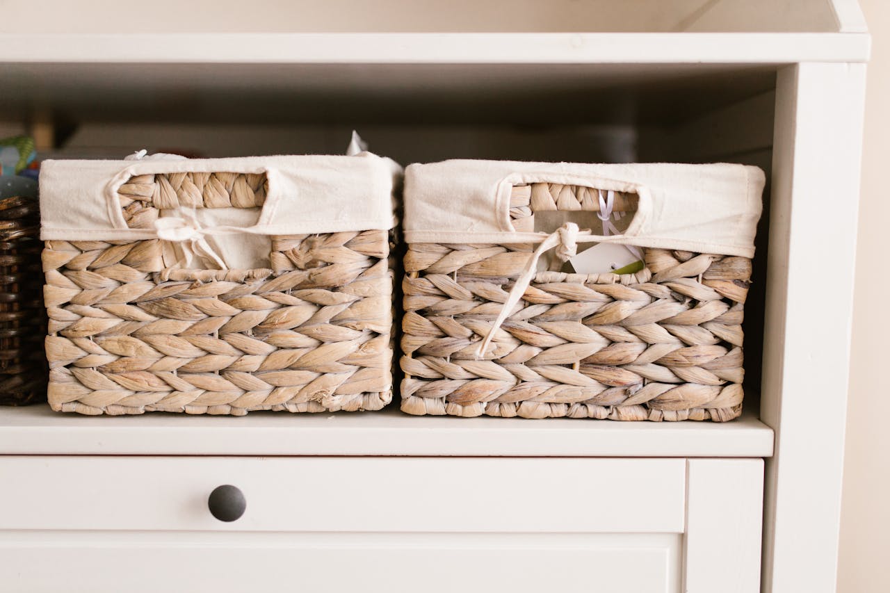 Stylish woven baskets neatly arranged on a white shelf for home organization solutions.